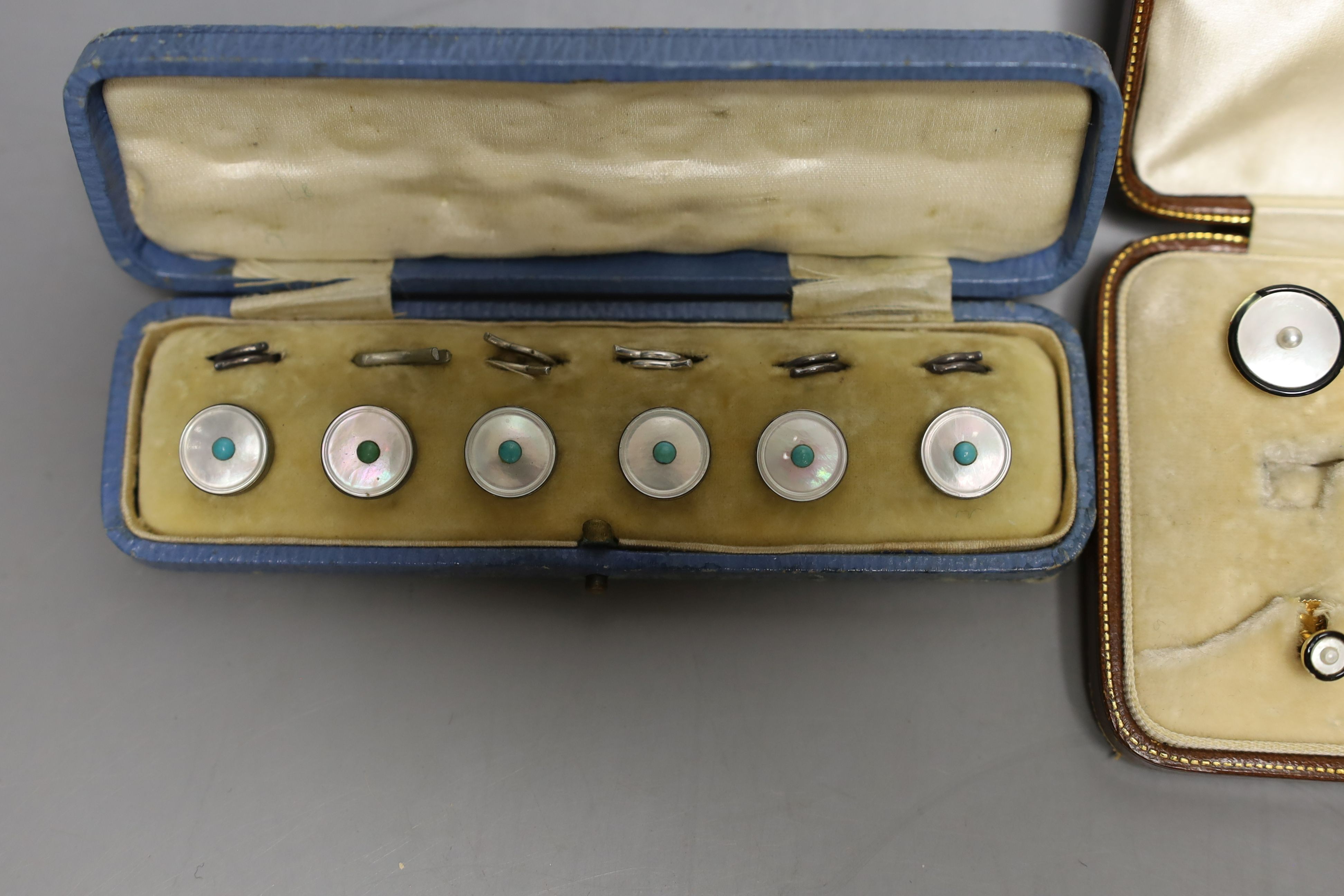 A set of four 18ct, mother of pearl, enamel and seed pearl set buttons, gross 7.2 grams, two similar 15ct studs, gross 2.3 grams and one other cased set of white metal dress studs.